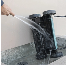 Reinigen van de onderkant van een verticuteermachine met een waterstraal.