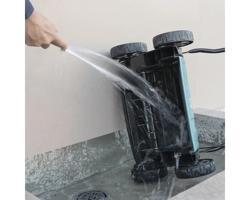 Reinigen van de onderkant van een verticuteermachine met een waterstraal.