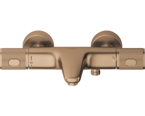 Thermostatische badkraan in geborsteld brons met gekartelde grepen, temperatuurbegrenzing op 38 graden en omsteller voor bad en douche.