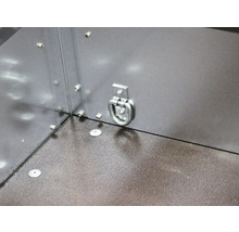 Metalen sjoroog aan de zijwand van een aanhangwagen voor ladingzekering boven een gestructureerde vloer.