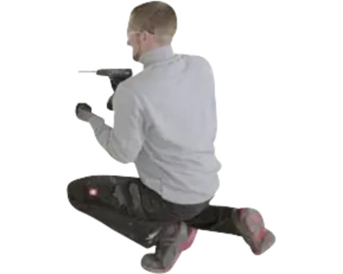 Een man in werkkleding knielt en werkt met een zwarte accuboorschroefmachine.