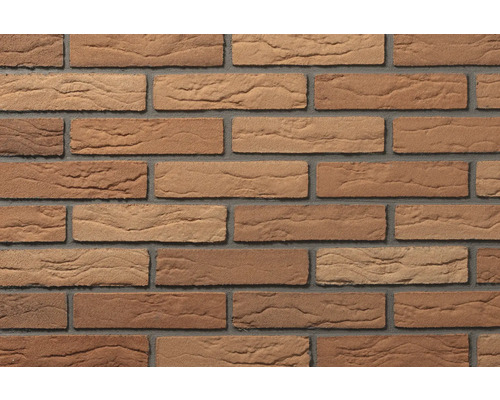 Steenstrips met baksteenlook en gestructureerd, rotsachtig oppervlak in bruintinten, gelegd met grijze voegen.