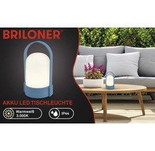 Briloner Logo, oplaadbare LED-tafellamp voor buiten, warmwit licht 3000 Kelvin, IP44 spatwaterdicht, draagbare lamp met handvat op een tuintafel.
