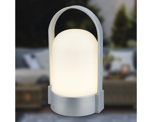Draagbare LED-tafellamp met zilverkleurige voet en beugelgreep, koepelvormige kap, warmwit licht.