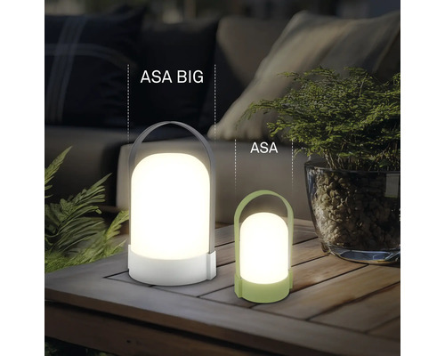 Twee moderne draagbare LED-tafellampen ASA BIG en ASA van kunststof op een houten tafel in een lichte, georganiseerde buitenruimte.