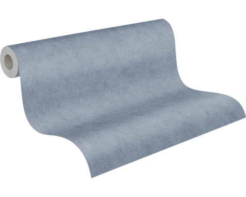Blauw vliesbehang met gestructureerd oppervlak in betonlook, licht uitgerold.