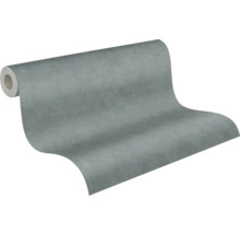 Vliesbehang met betonlook, gestructureerd, grijs, gedeeltelijk uitgerold.