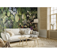 Woonkamer met fotobehang met tropische planten, witte bank en houten meubels. Lichte, georganiseerde ruimte met parketvloer.