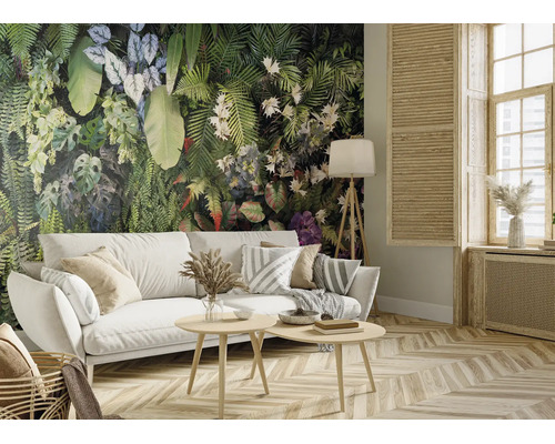 Woonkamer met fotobehang met tropische planten, witte bank en houten meubels. Lichte, georganiseerde ruimte met parketvloer.