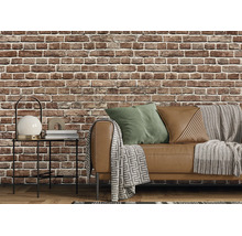 Vliesbehang met baksteenmotief in een woonkamer in industriële stijl met bank, bijzettafel en textiel.
