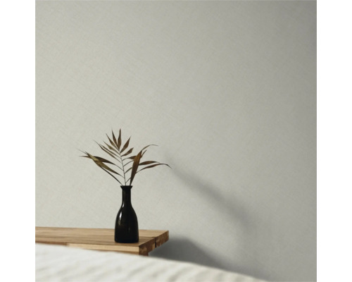 Vliesbehang met fijne linnenstructuur in een minimalistische ruimte met houten tafel en vaas.