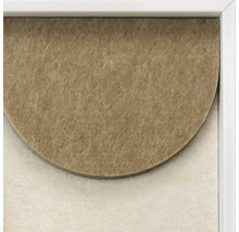 Close up van een wanddecoratie in een lijst met een gestructureerde halve cirkel van vezelachtig materiaal.