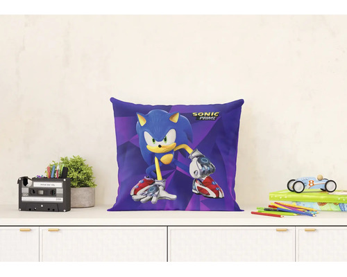 Decoratief kussen met Sonic Prime afbeelding en logo op een witte ladekast in een lichte, georganiseerde kinderkamer met planten en speelgoed.