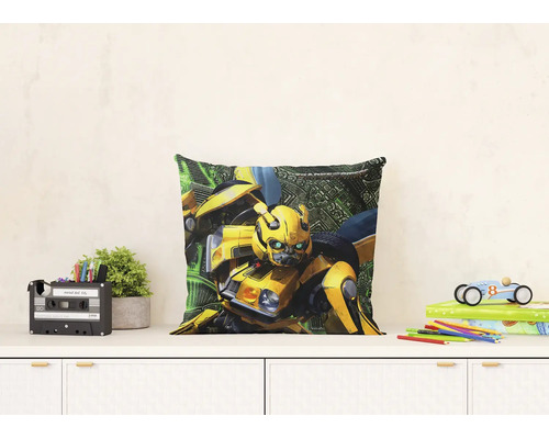 Vierkant sierkussen met het Transformers personage Bumblebee op een wit dressoir in een lichte kinderkamer.