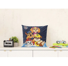 Lichte en georganiseerde scène met een vierkant Paw Patrol sierkussen met Marshall, Chase, Rubble en Skye op een bureau.