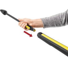 Een hand plaatst een spuitlans in een hogedrukpistool, aangegeven met een pijl voor de verbinding.