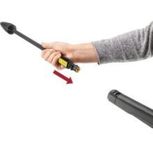 Een hand sluit een spuitlans aan op het pistool van een hogedrukreiniger, aangegeven door een pijl.