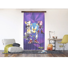 Moderne, lichte kinderkamer met een Sonic Prime gordijn, een comfortabele fauteuil en een georganiseerde werkplek.
