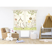 Gordijn met patroon voor de kinderkamer met bloemen, vogels en een vogelhuisje in een lichte kamer met fauteuil, teddyberen en een babybedje.