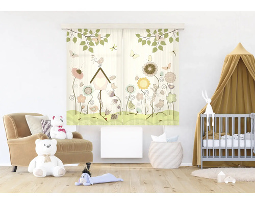 Gordijn met patroon voor de kinderkamer met bloemen, vogels en een vogelhuisje in een lichte kamer met fauteuil, teddyberen en een babybedje.