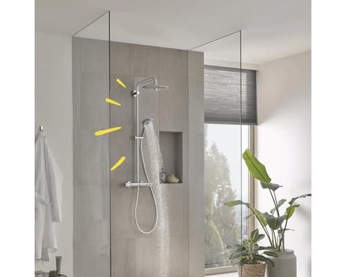 Modern douchesysteem met regendouche, handdouche en glazen wand in een lichte badkamer met betegelde wand.