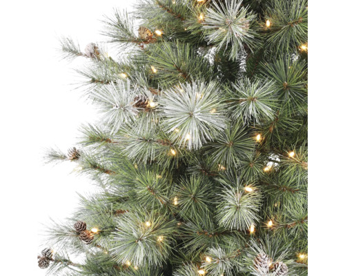 Kunstkerstboom met warmwitte LED-verlichting, dennenappels en besneeuwde naalden in detail.