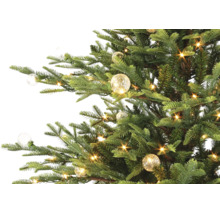 Kunstkerstboom met warmwitte ledverlichting en decoratieve glazen bollen.