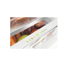 Detailopname van een koelkastlade met VitControl Plus-functie, gevuld met vers fruit en groenten zoals wortelen en radijsjes.