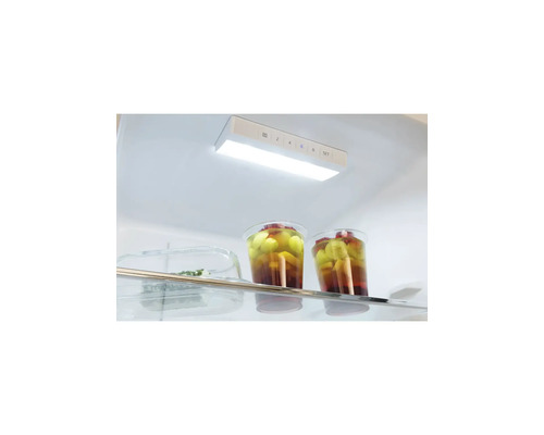 Helder en georganiseerd interieur van een koelkast met LED-verlichting en temperatuurregeling boven een glazen plateau.