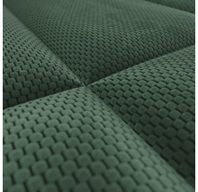 Detailopname van een groene structuurstof met wafelpatroon en een gewatteerd oppervlak.