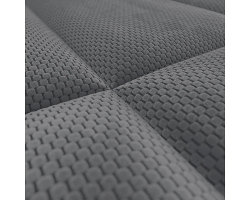 Close-up van een grijze, gestructureerde meubelstof met een ruitpatroon en stiksels.