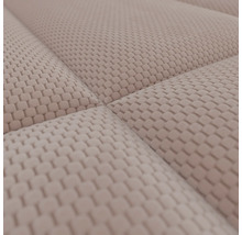 Detailopname van een beige, gestructureerde meubelstof met een verhoogd wafelpatroon en zichtbare naden.