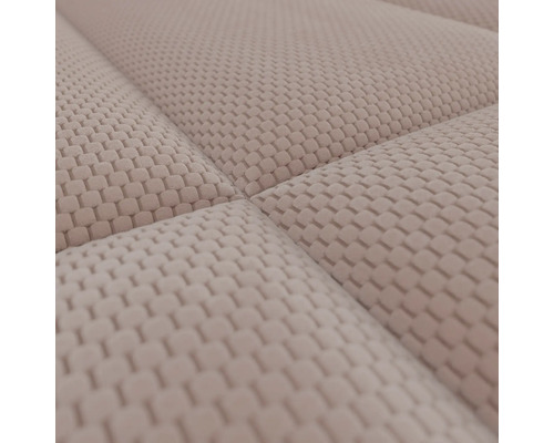 Detailopname van een beige, gestructureerde meubelstof met een verhoogd wafelpatroon en zichtbare naden.