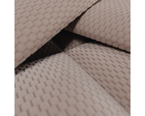 Detailopname van een beige stof met een klein wafelpatroon of honingraatstructuur.