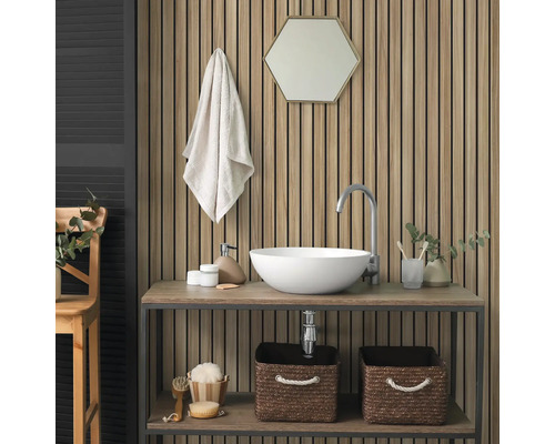 Akoestisch paneel met houten lamellen op een badkamerwand achter een wastafel met witte opzetwastafel en zeshoekige spiegel.
