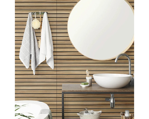 Wandbekleding met houtlook en horizontale latten in een lichte, moderne badkamer met ronde spiegel en witte opzetwastafel.