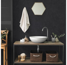 Moderne badkamer met ronde opzetwastafel, hoge kraan, zeshoekige spiegel en twee gevlochten opbergmanden op een houten rek.