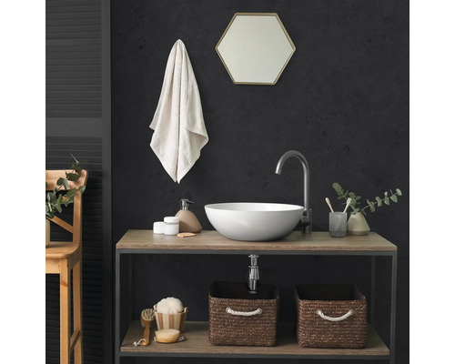 Moderne badkamer met ronde opzetwastafel, hoge kraan, zeshoekige spiegel en twee gevlochten opbergmanden op een houten rek.