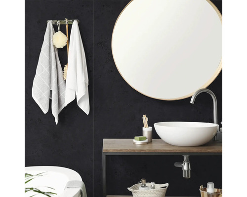 Moderne badkamer met ronde spiegel, witte opzetwastafel op een houten wastafelblad en donkere wandpanelen met textuur.