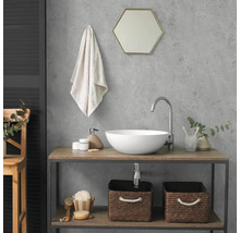 Moderne badkamer met ronde opzetwastafel, hoge kraan en een wastafelmeubel van hout en metaal. Boven de wastafel hangt een zeshoekige spiegel.