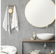 Moderne badkamer met ronde spiegel, witte waskom op houten tafel en grijze wandpanelen met betonlook.