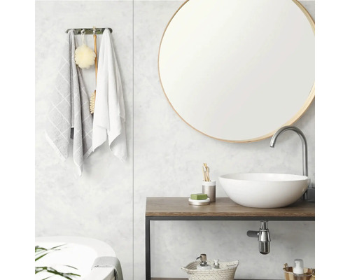 Moderne badkamer met ronde spiegel, opzetwastafel op houten console, handdoekhouder en wandpanelen.