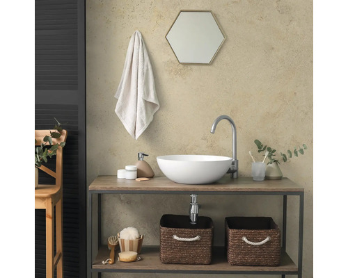 Moderne badkamer met witte opzetwastafel op houten meubel, hoge kraan, zeshoekige spiegel en opbergmanden.