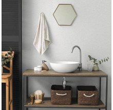 Moderne badkamer met witte opzetwastafel, hoge kraan, zeshoekige spiegel en houten wastafelmeubel met opbergmanden.