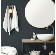 Moderne badkamer met een ronde wandspiegel, een witte opzetwastafel op een houten blad en handdoekhouder.