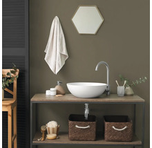 Moderne badkamer met witte opzetwastafel op een houten wastafelmeubel, zilveren kraan en gevlochten opbergmanden.