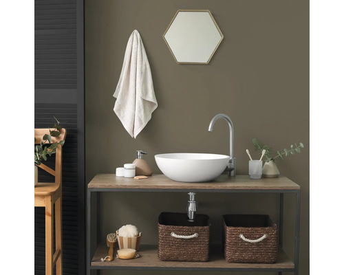 Moderne badkamer met witte opzetwastafel op een houten wastafelmeubel, zilveren kraan en gevlochten opbergmanden.