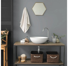 Moderne badkamer met witte opzetwastafel op een houten wastafelmeubel, hoge kraan, zeshoekige spiegel en gevlochten manden.