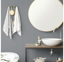 Moderne badkamer met ronde spiegel, witte opzetwastafel op een houten blad, grijze wand en wandhaak met handdoeken.
