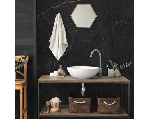 Moderne badkamer met witte opzetwastafel op houten meubel, donkere marmeren wand, zeshoekige spiegel en gevlochten opbergmanden.